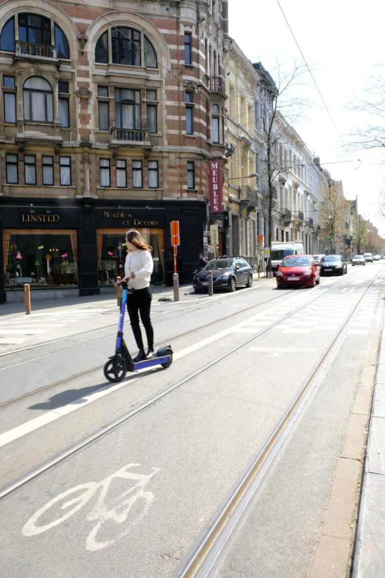 a woman riding a scooter on a city street